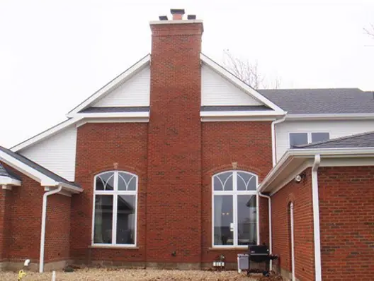 Brick gable end with a chimney and arched transom windows installed by C.B.E. Construction